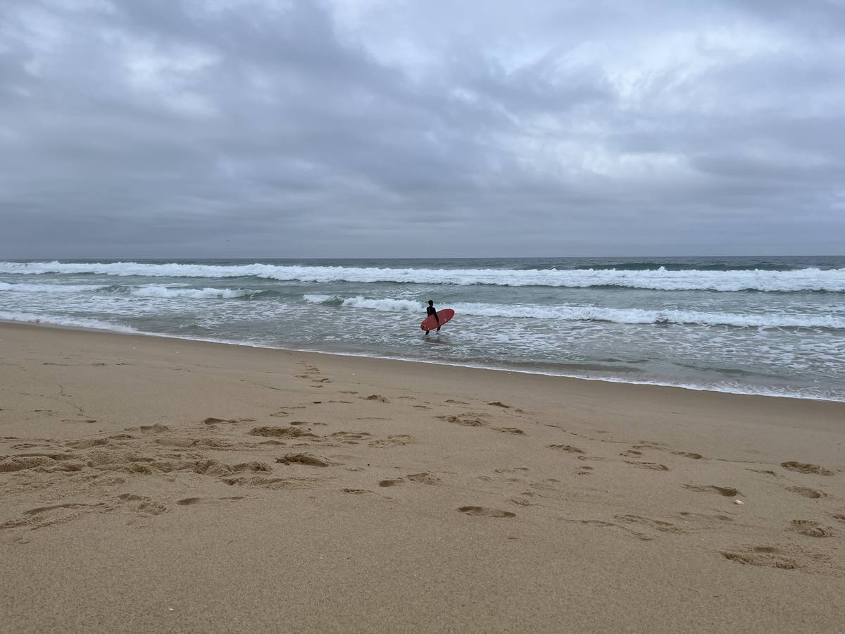 Wavemakers — surfer entering the Atlantic