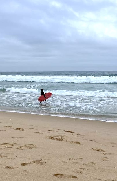 Wavemakers — surfer entering the Atlantic